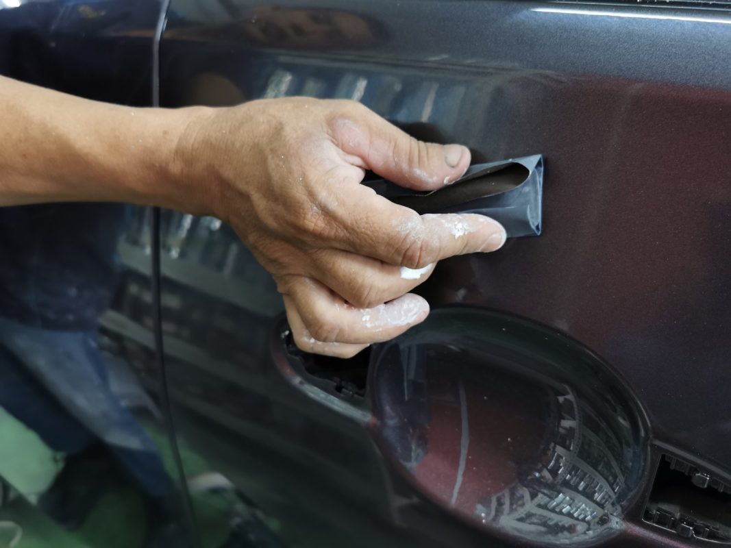 Machine polishing a panel on the Nissan Almera to a mirror finish.