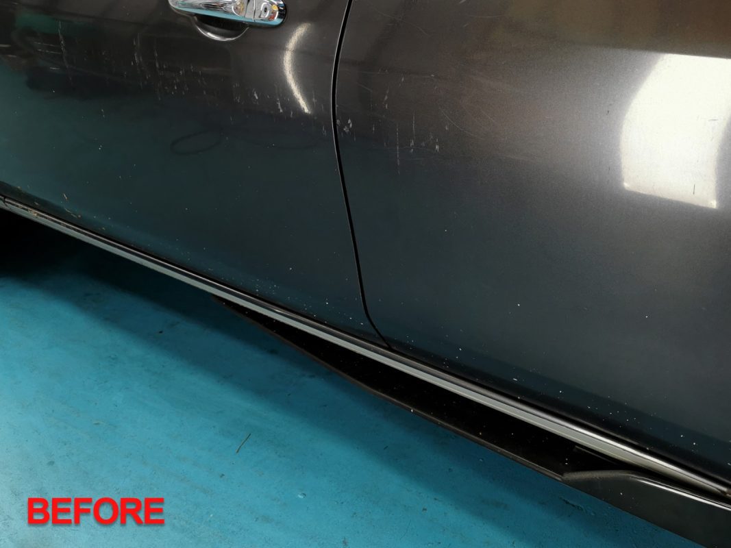 The Nissan Almera from a three-quarter angle in the workshop after the respray.