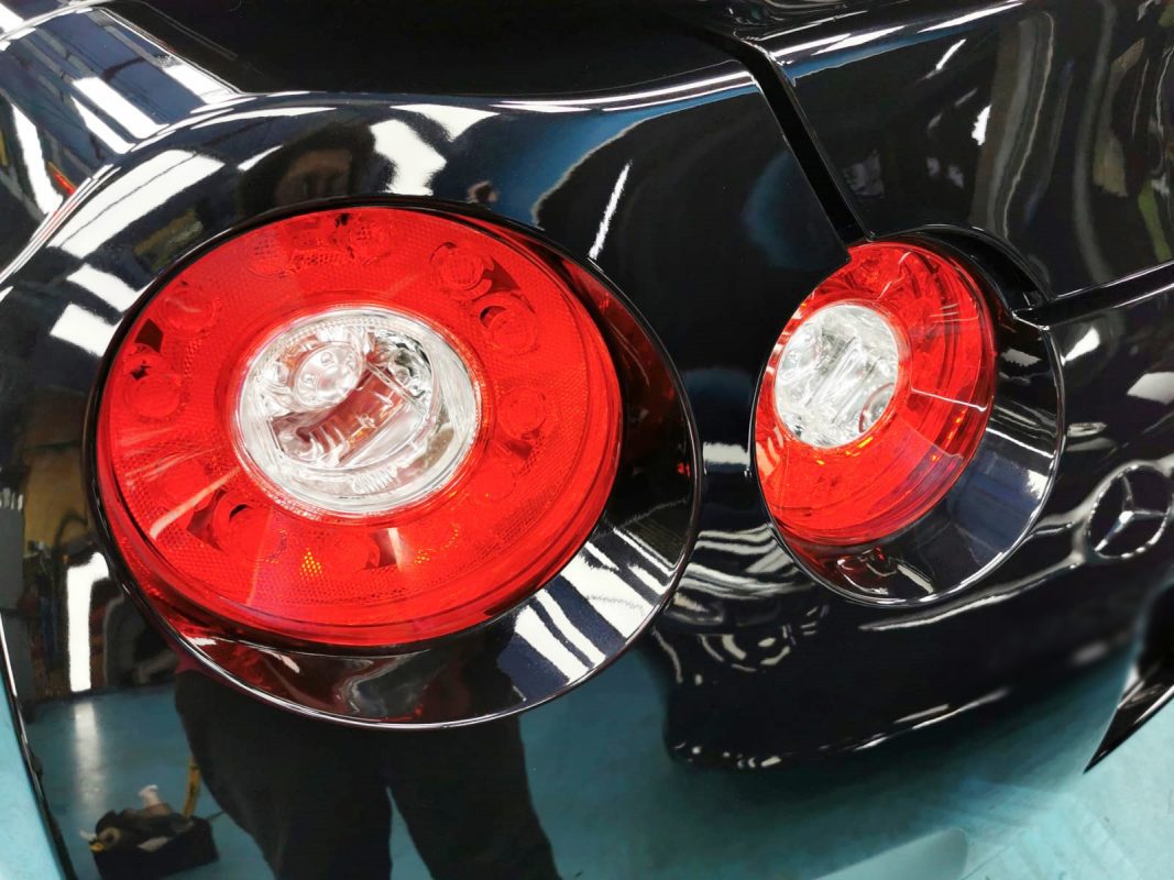 The coated bonnet of the Nissan GT-R under workshop lighting.