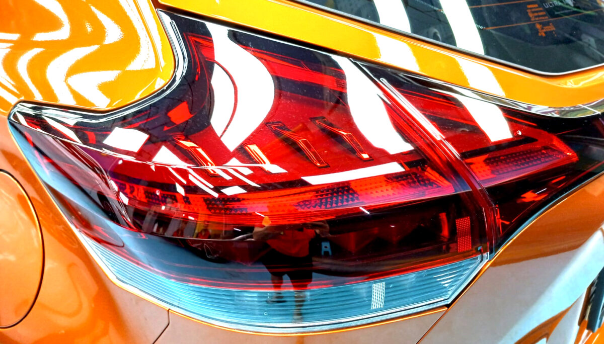 The coated bonnet of the Nissan Kicks under workshop lighting.