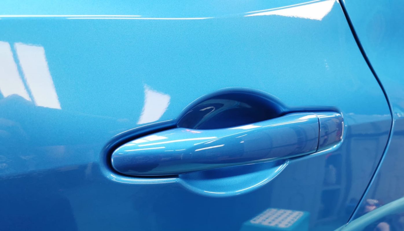The coated bonnet of the Nissan Note E-Power under workshop lighting.