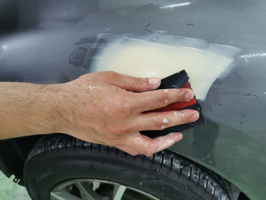 Wet-sanding the Note's panels to smooth the existing paintwork.