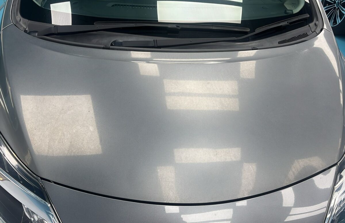 The Nissan Note from a second angle on arrival, paintwork showing damage and fading.