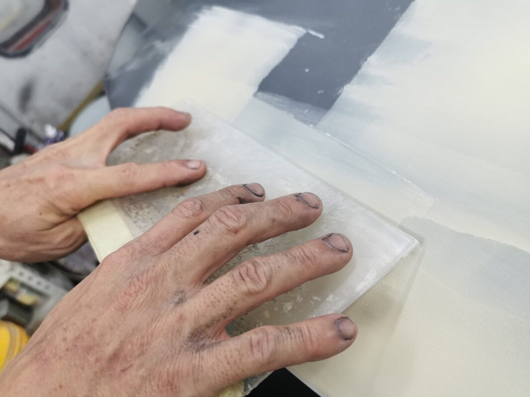 Wet-sanding a panel on the Nissan Note to smooth and level the surface.