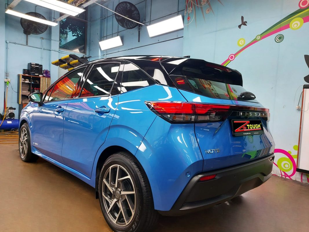 The coated bonnet of the Nissan Note under workshop lighting.