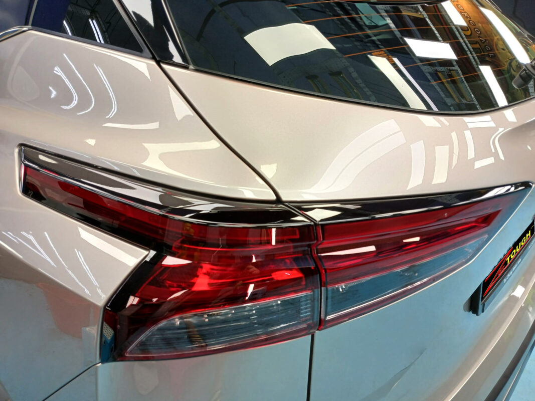 The coated bonnet of the Nissan Qashqai under workshop lighting.