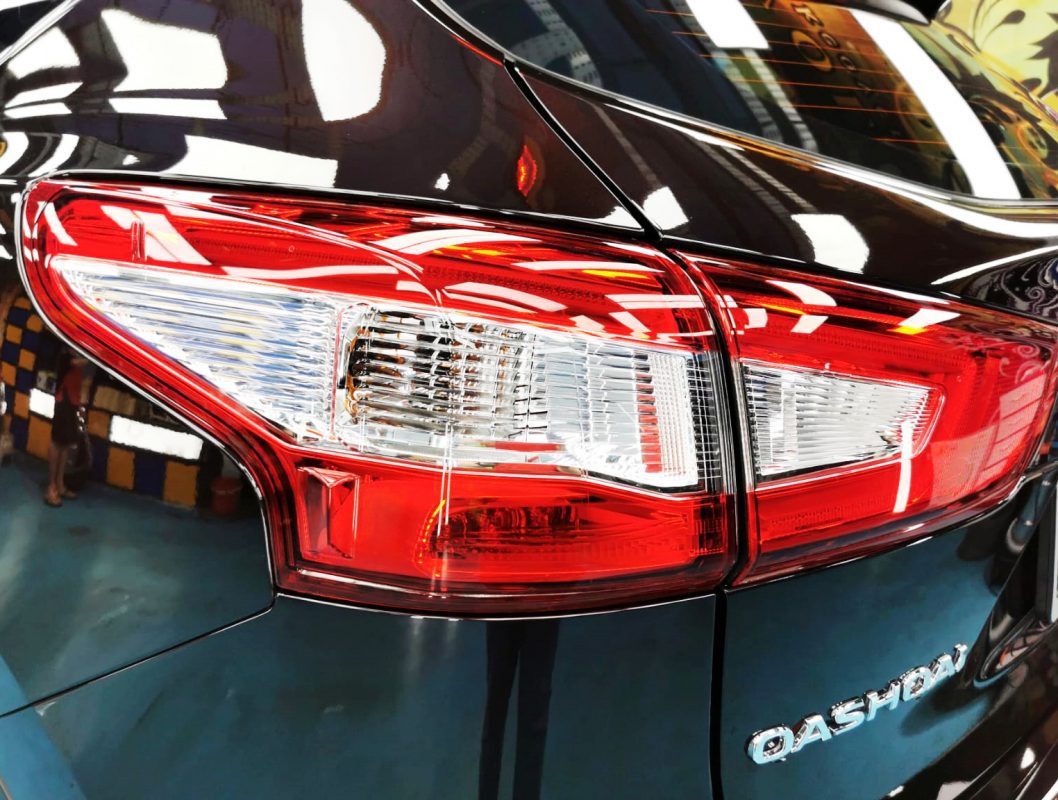 The coated bonnet of the Nissan Qashqai under workshop lighting.