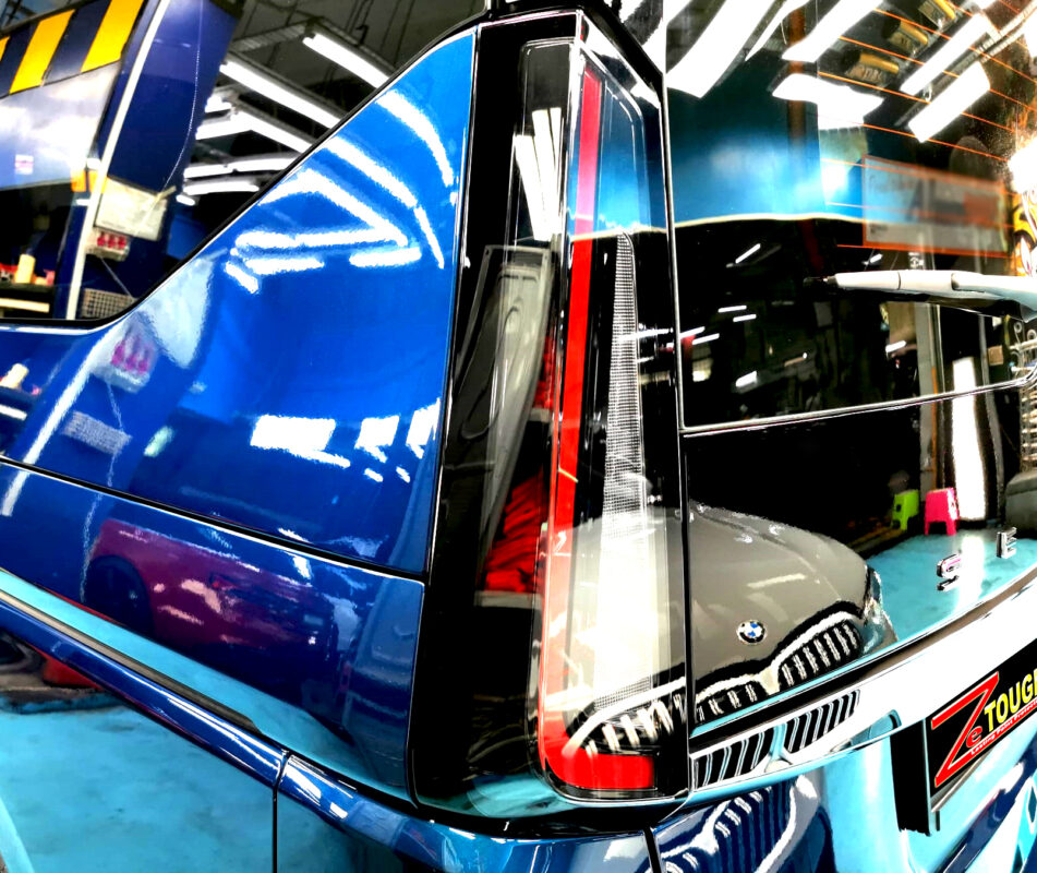 The coated bonnet of the Nissan Serena under workshop lighting.