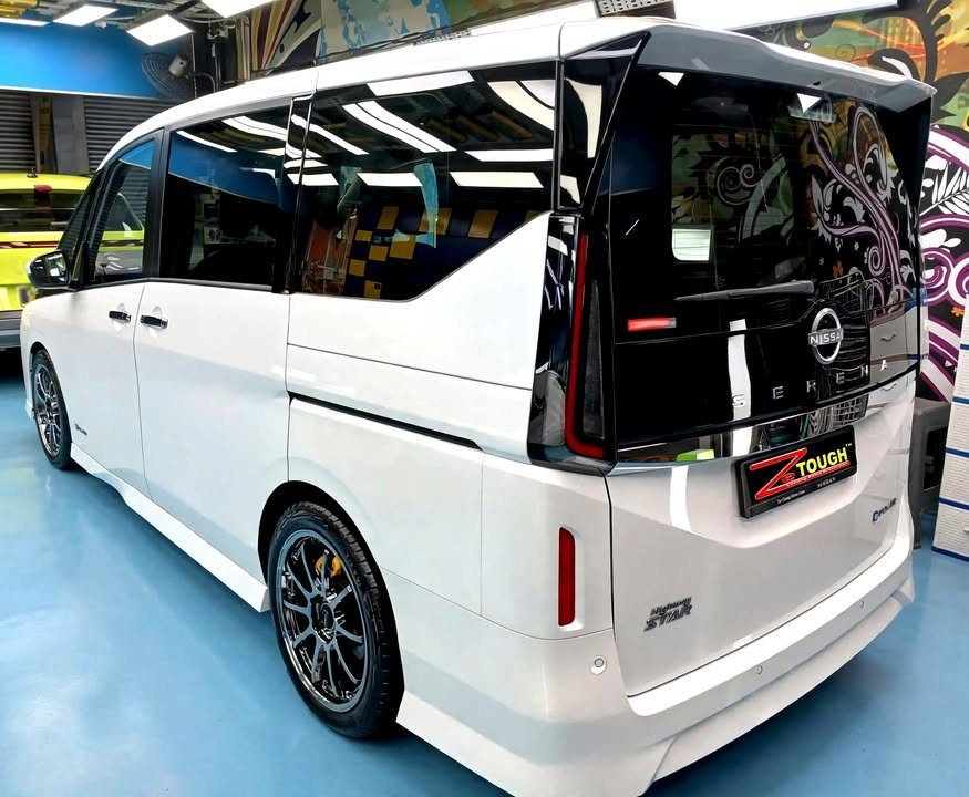 Rear three-quarter view of the white Nissan Serena with tinted rear glass and alloy wheel.
