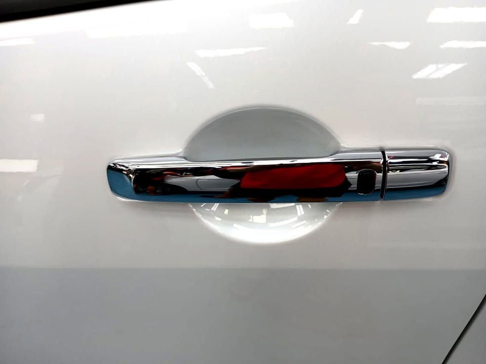 Chrome door handle on the white side panel.
