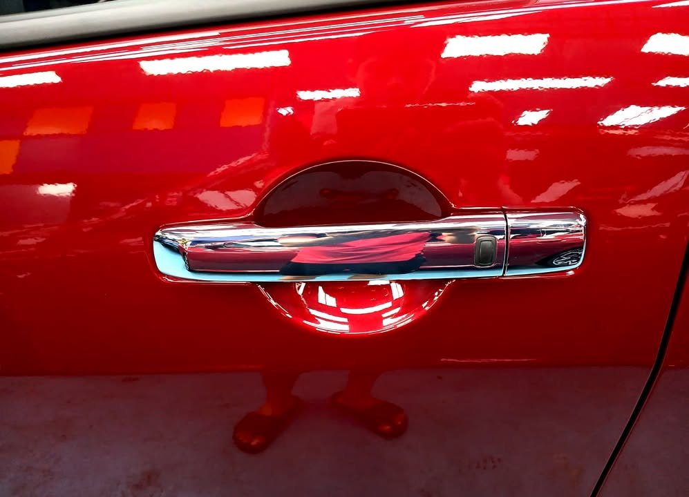 Chrome door handle on the red door panel.