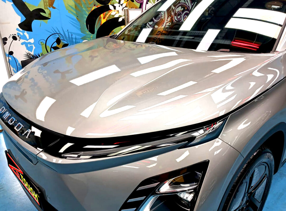 The OMODA E5's coated paintwork under workshop lighting.