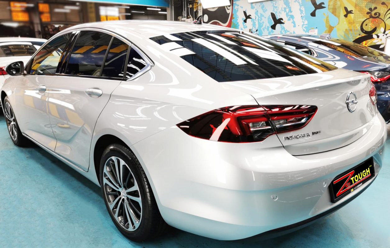 The coated bonnet of the Insignia Grandsport under workshop lighting.