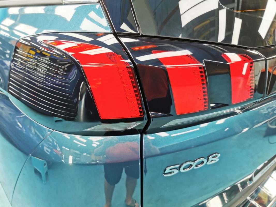 The coated bonnet of the Peugeot 5008 under workshop lighting.