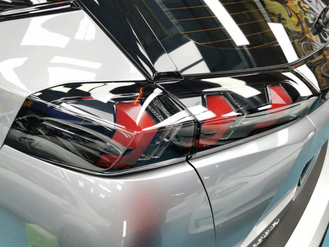 The coated bonnet of the Peugeot e-2008 GT under workshop lighting.