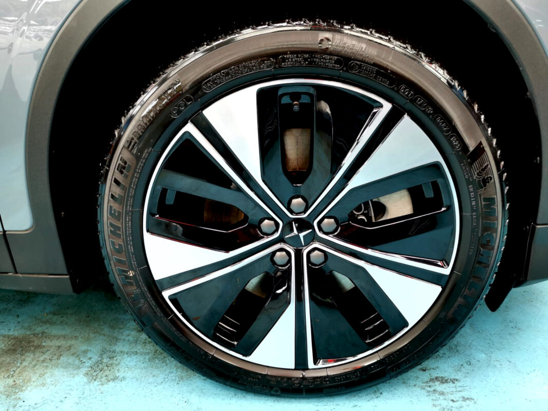 Close-up of the Polestar 2's coated surface under workshop lighting.