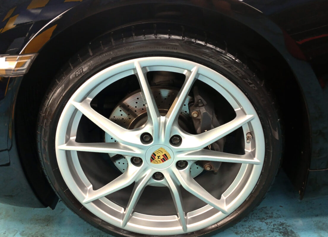 Close-up of the 718 Cayman's coated surface under workshop lighting.