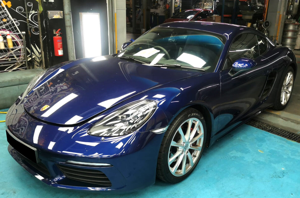The Porsche 718 Cayman as it arrived at Revol Carz, front three-quarter view showing the original paintwork.
