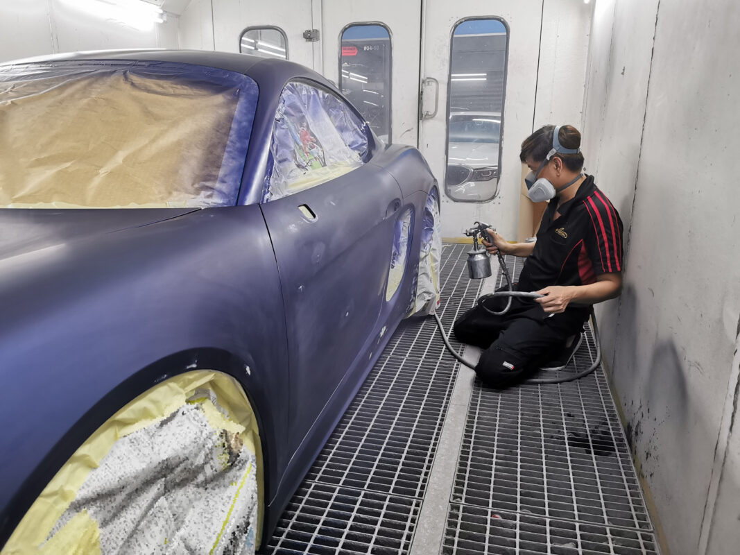 Machine-polishing the 718 Cayman after the paint is oven-baked, bringing out the gloss.