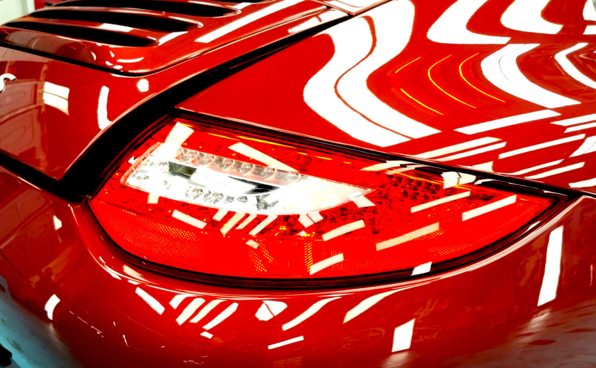 Close-up of the 911 Carrera S's coated surface under workshop lighting.