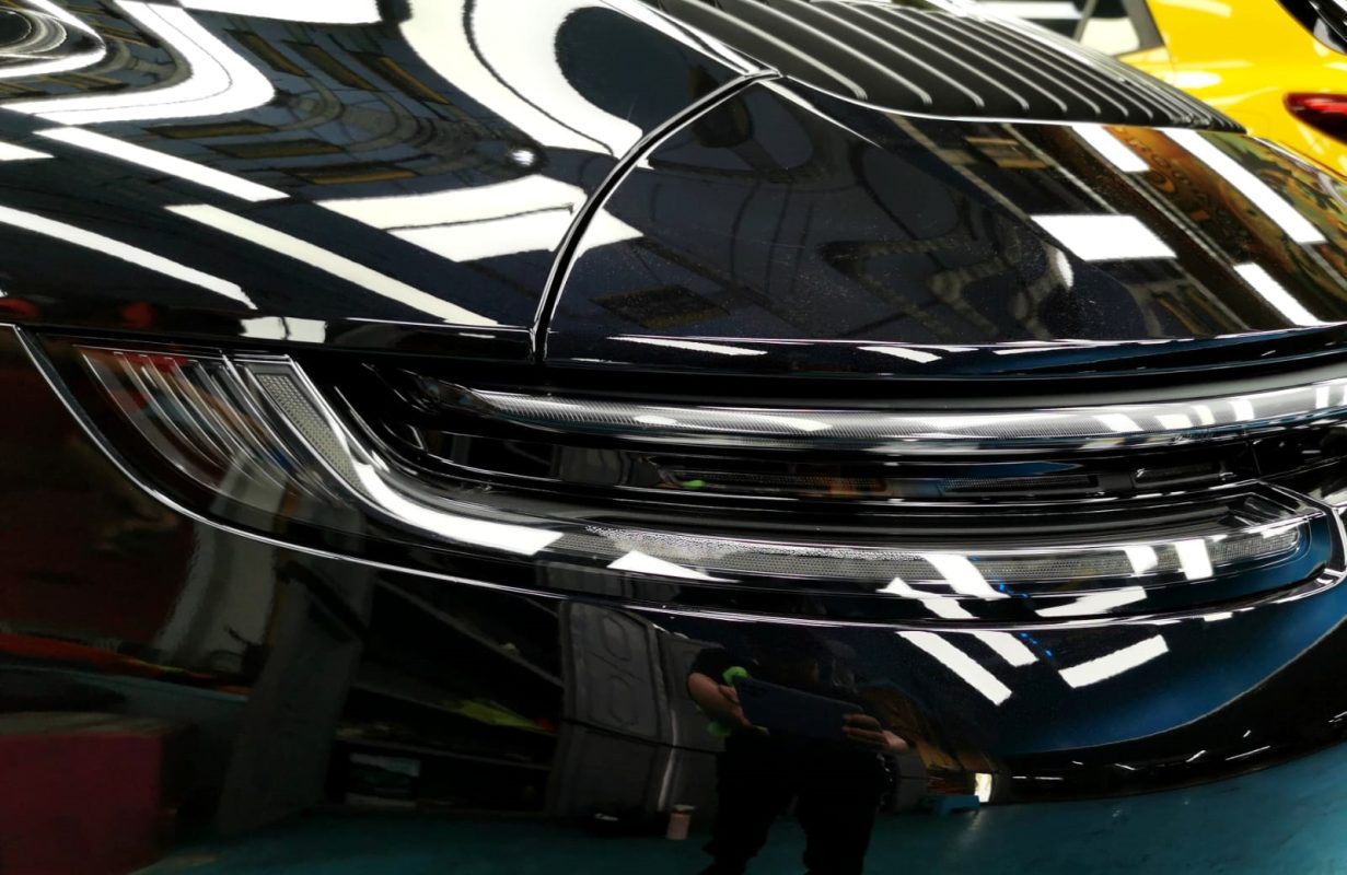 Close-up of the 911 Carrera's coated surface under workshop lighting.