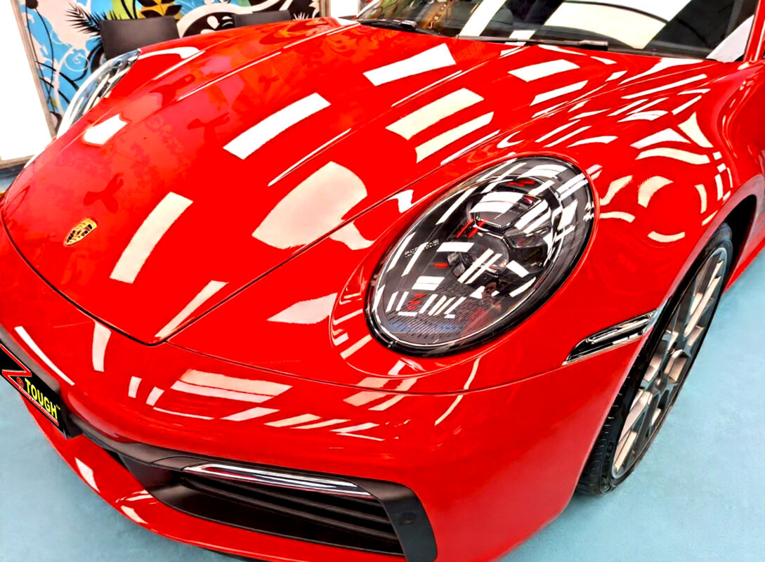 The Porsche 911 Carrera's coated paintwork under workshop lighting.