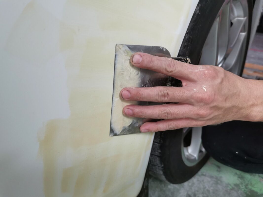 Body filler patched onto a panel of the Porsche 911 to level the surface.