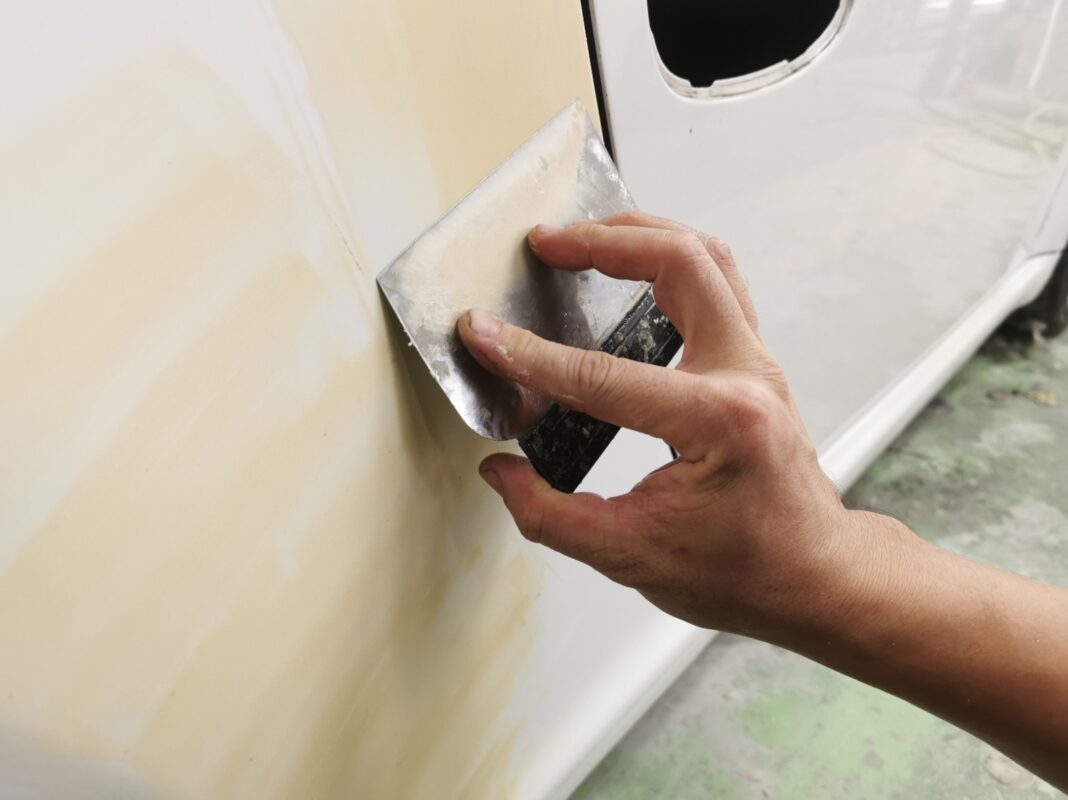 Wet-sanding a filled panel on the Porsche 911 smooth before paint.