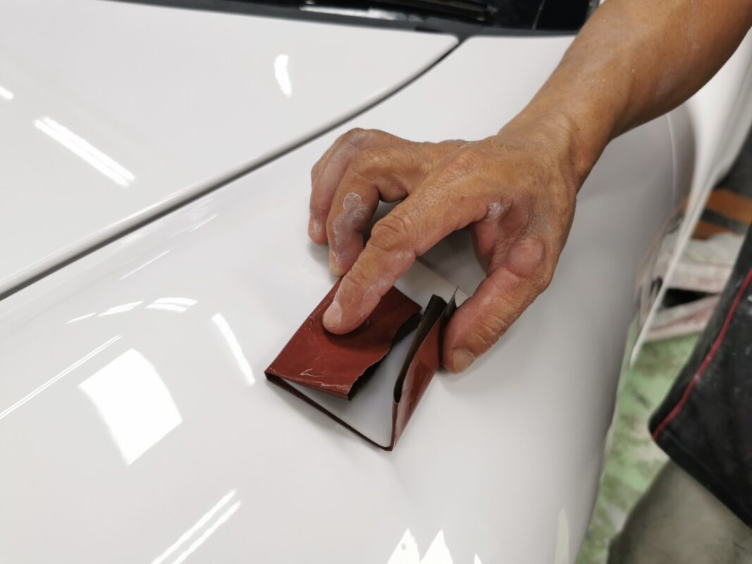 Wet-sanding the Porsche 911's hood after the new coat was laid.