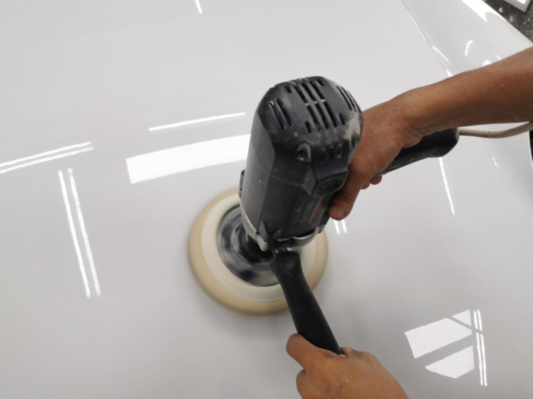 Compound-polishing the Porsche 911's hood to a mirror finish.