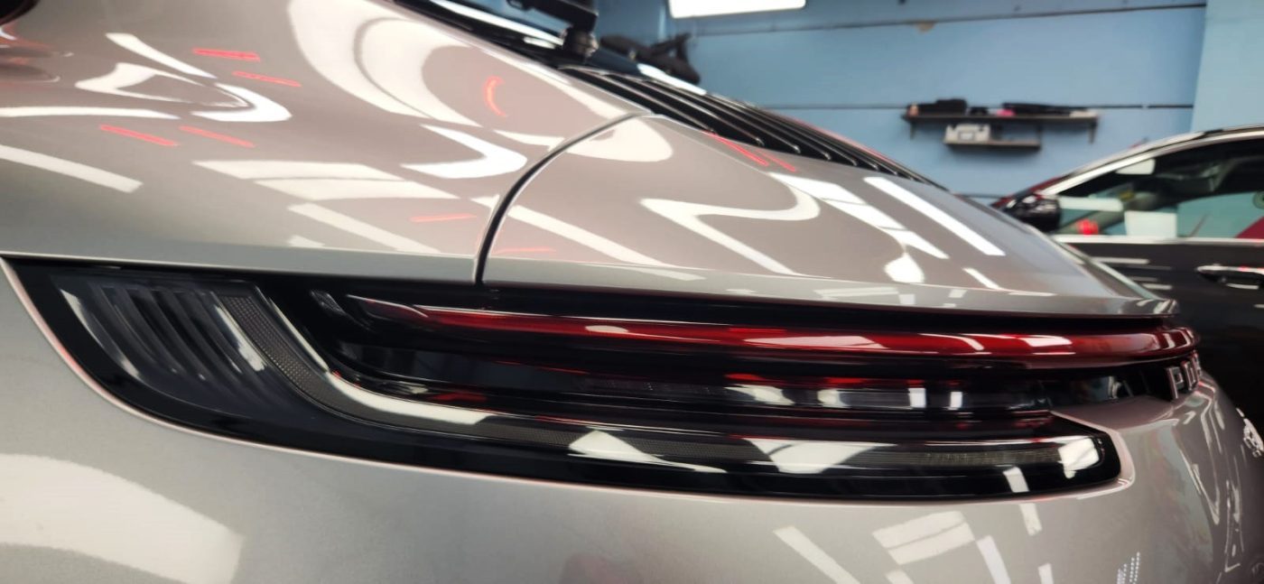 The coated bonnet of the 911 Panamera under workshop lighting.