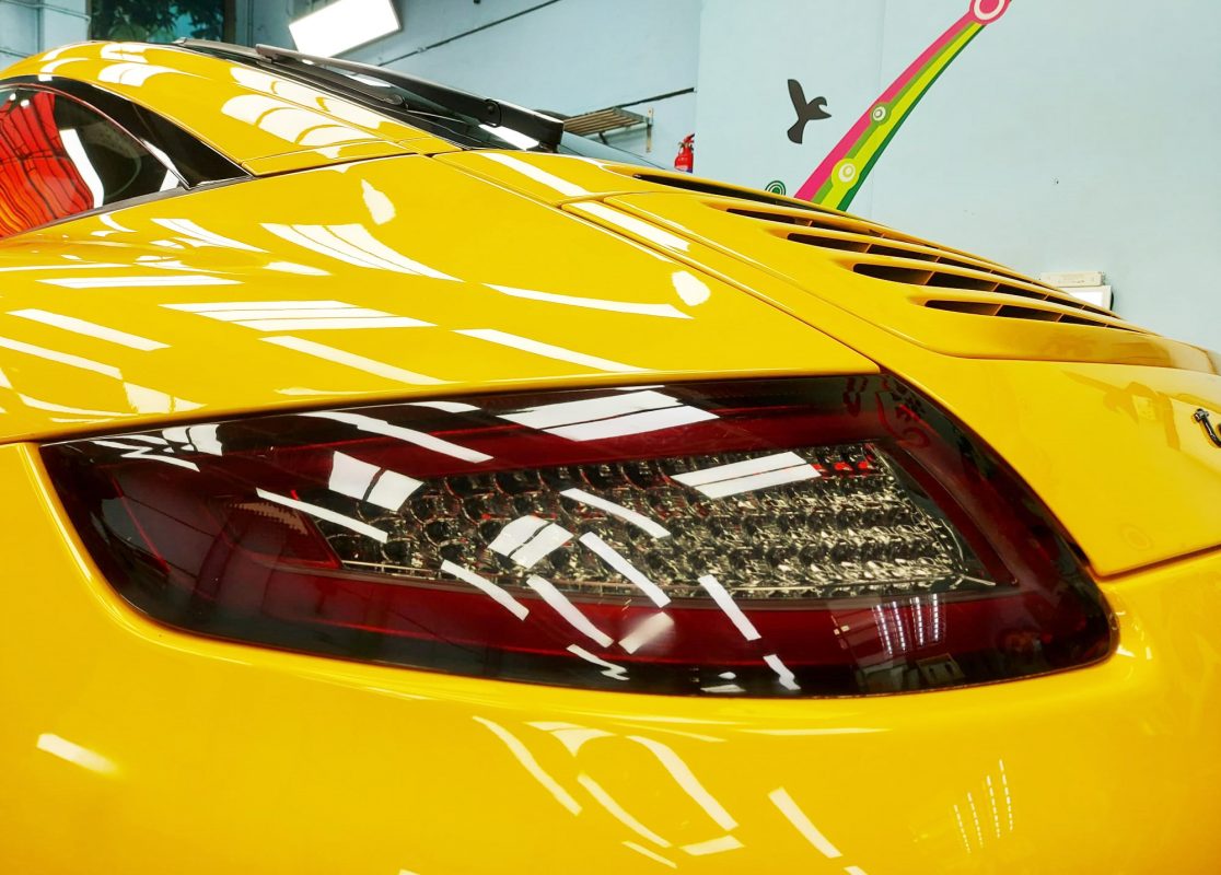 The coated bodywork of the Porsche 911 Targa under workshop lighting.