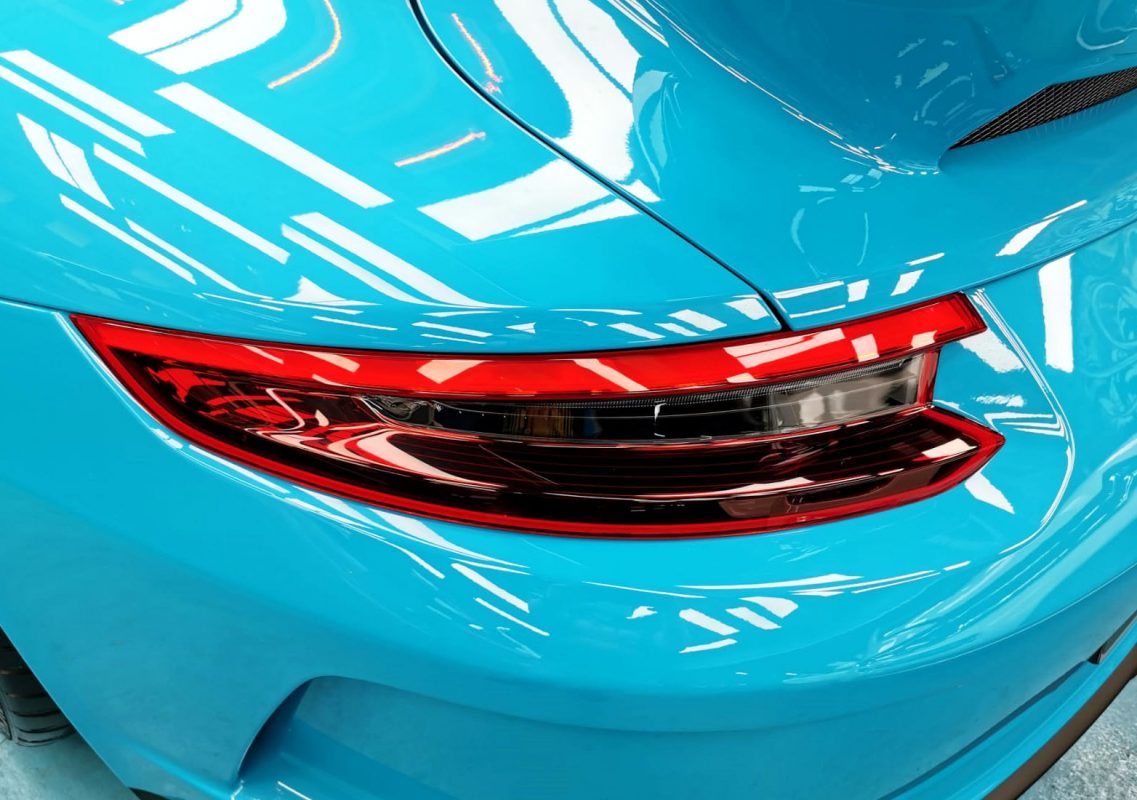 The coated bonnet of the Porsche 911 under workshop lighting.