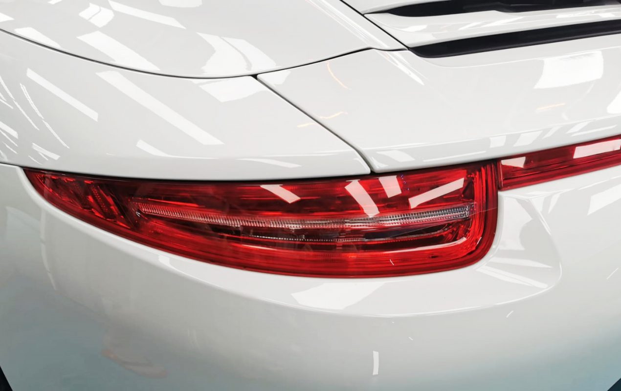 The coated bonnet of the Porsche 911 under workshop lighting.