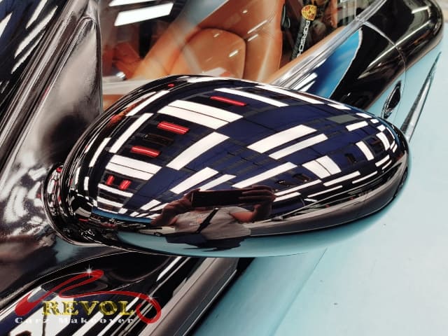 The coated bonnet of the Porsche C4 Coupe under workshop lighting.