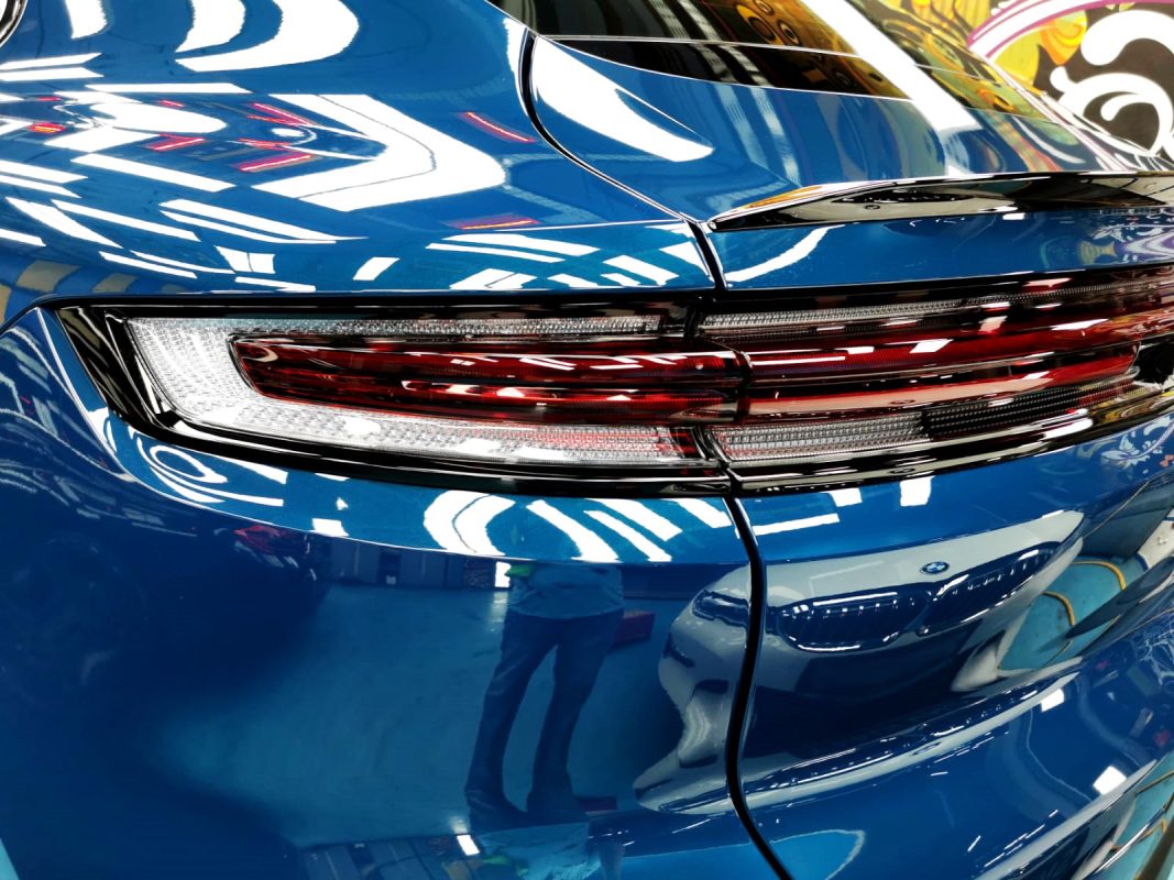 The coated bonnet of the Porsche Cayenne under workshop lighting.
