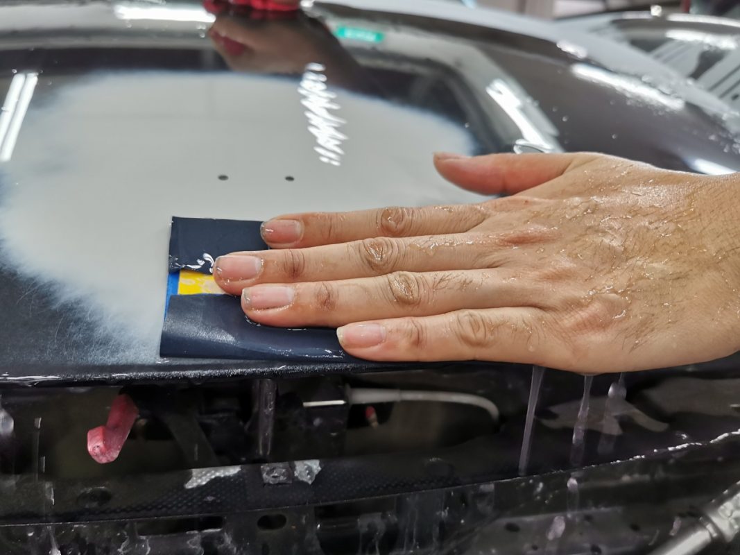 Wet-sanding the Cayman's panels to smooth the surface.