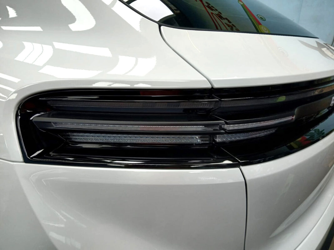 The coated bonnet of the Porsche Macan under workshop lighting.