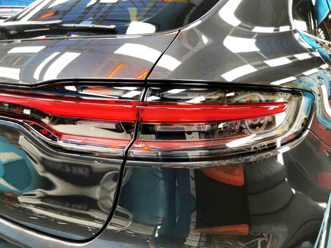 The coated bonnet of the Porsche Macan under workshop lighting.
