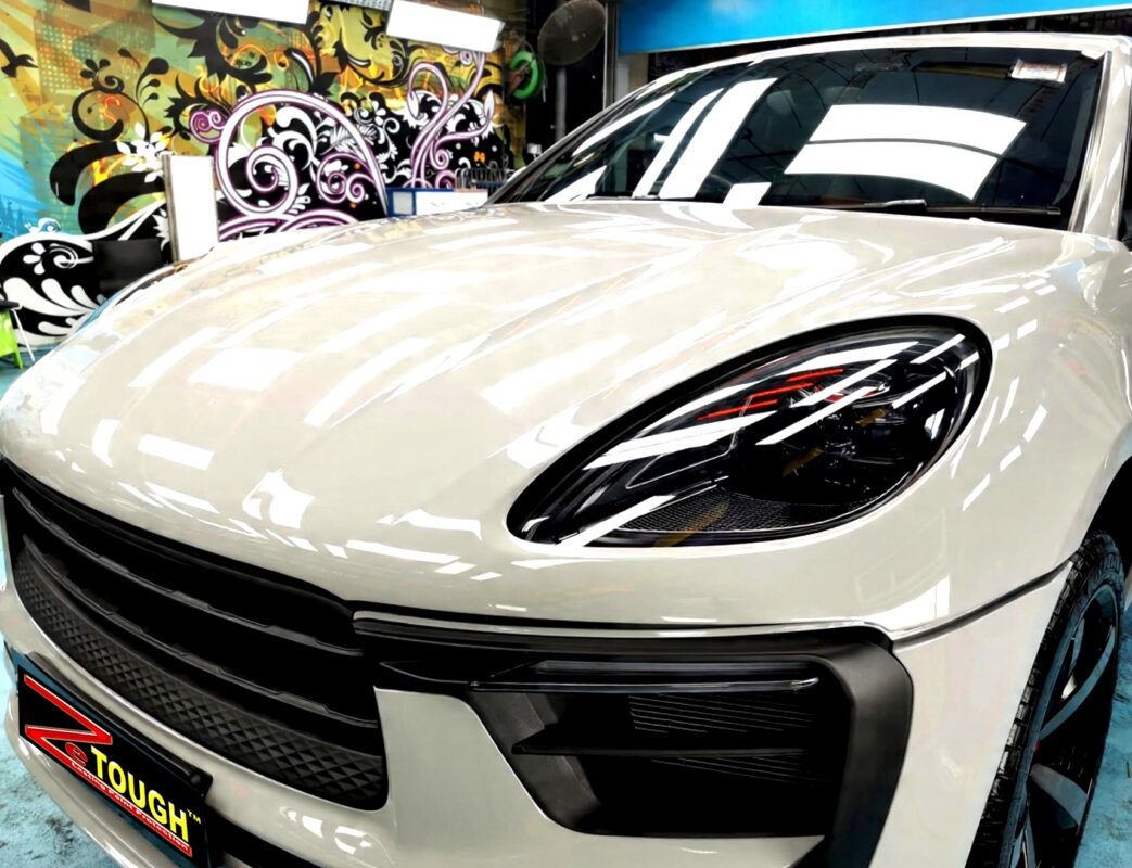 The Porsche Macan's coated paintwork under workshop lighting.