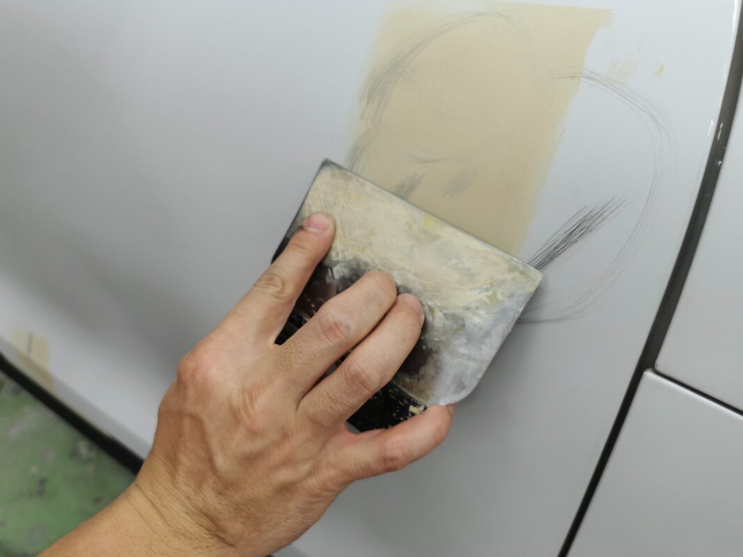 Damaged areas being patched and smoothed on the Porsche Macan.