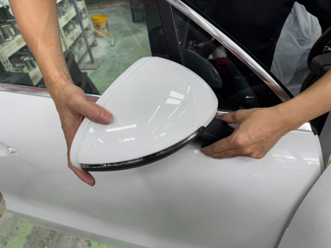 Previously removed car parts being refitted onto the Porsche Macan.