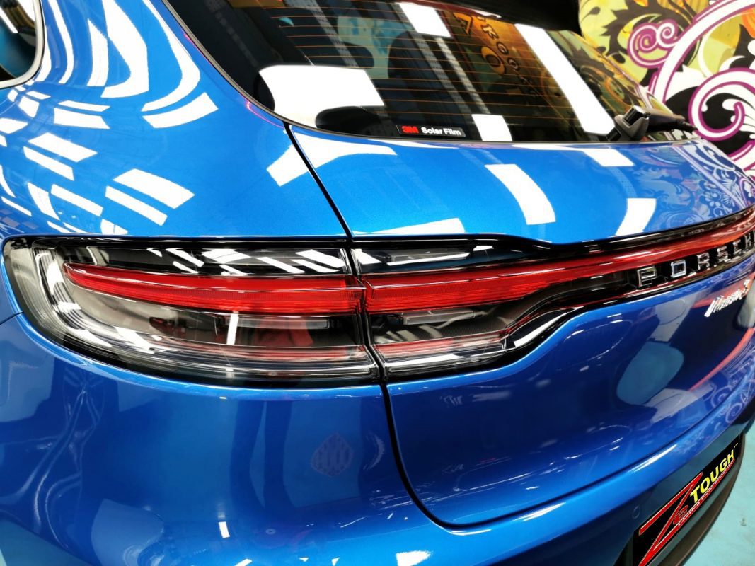The coated bonnet of the Porsche Macan S under workshop lighting.