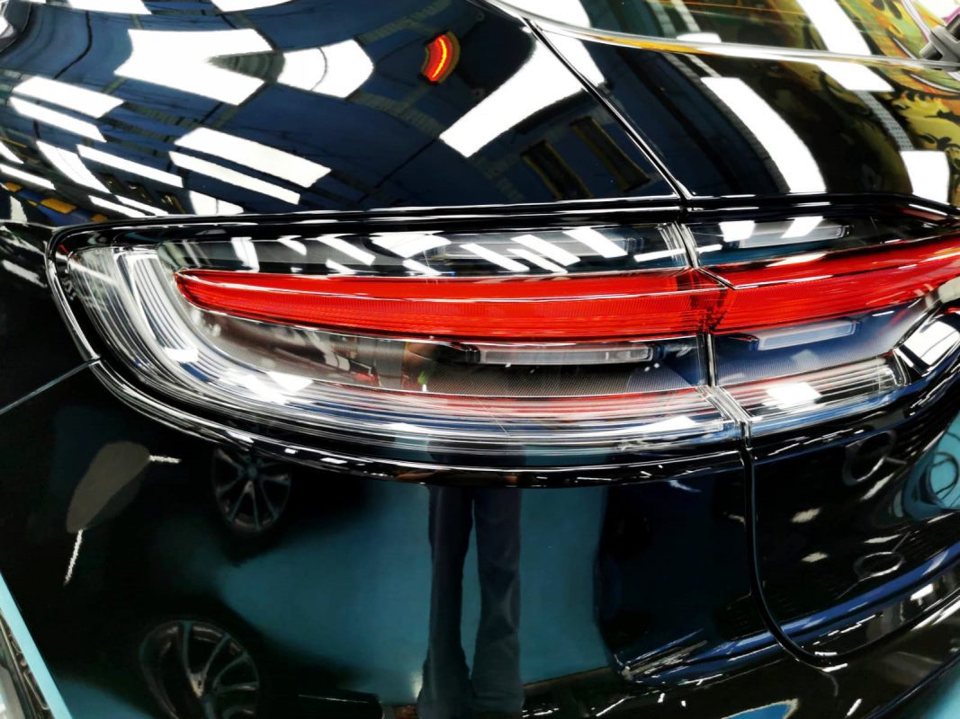 The coated bonnet of the Porsche Macan under workshop lighting.