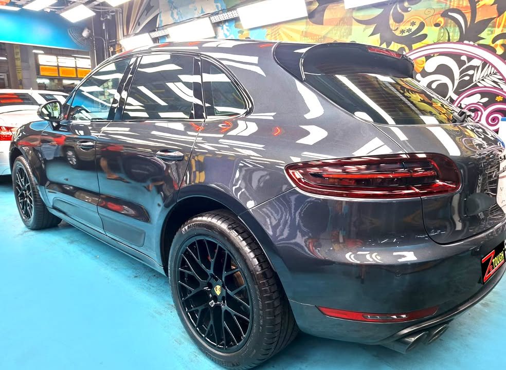 Rear three-quarter view of the dark grey Porsche Macan with a ZeTough plate.