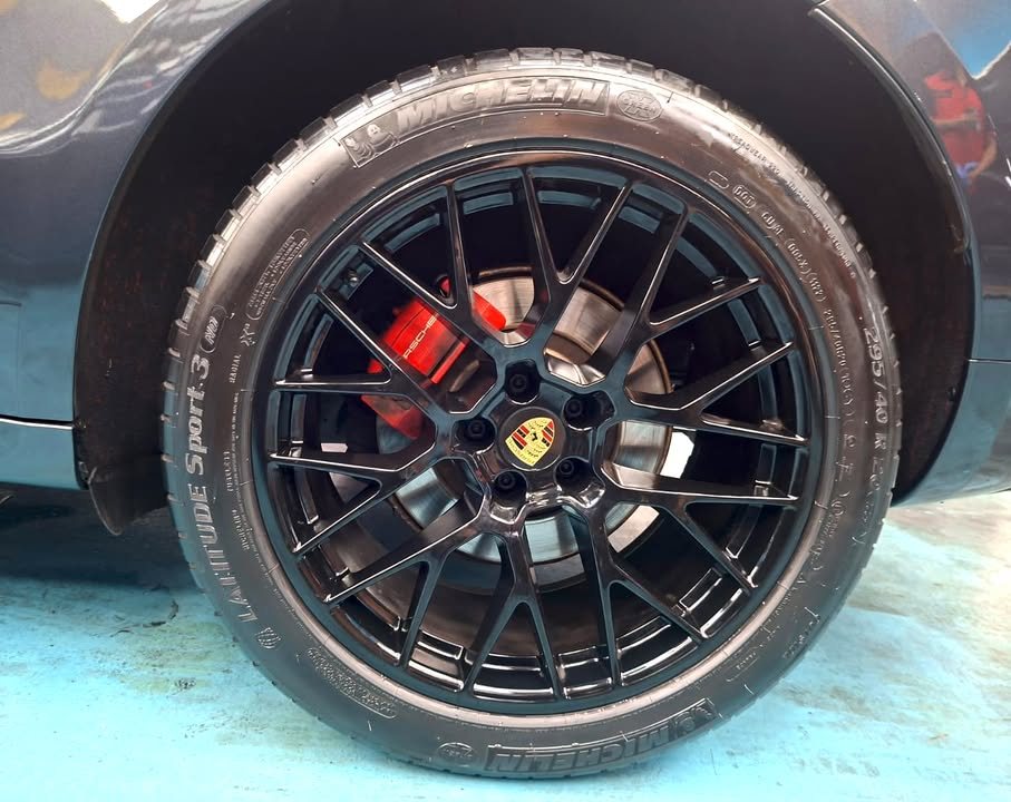 Black multi-spoke wheel with red brake caliper on the Macan.