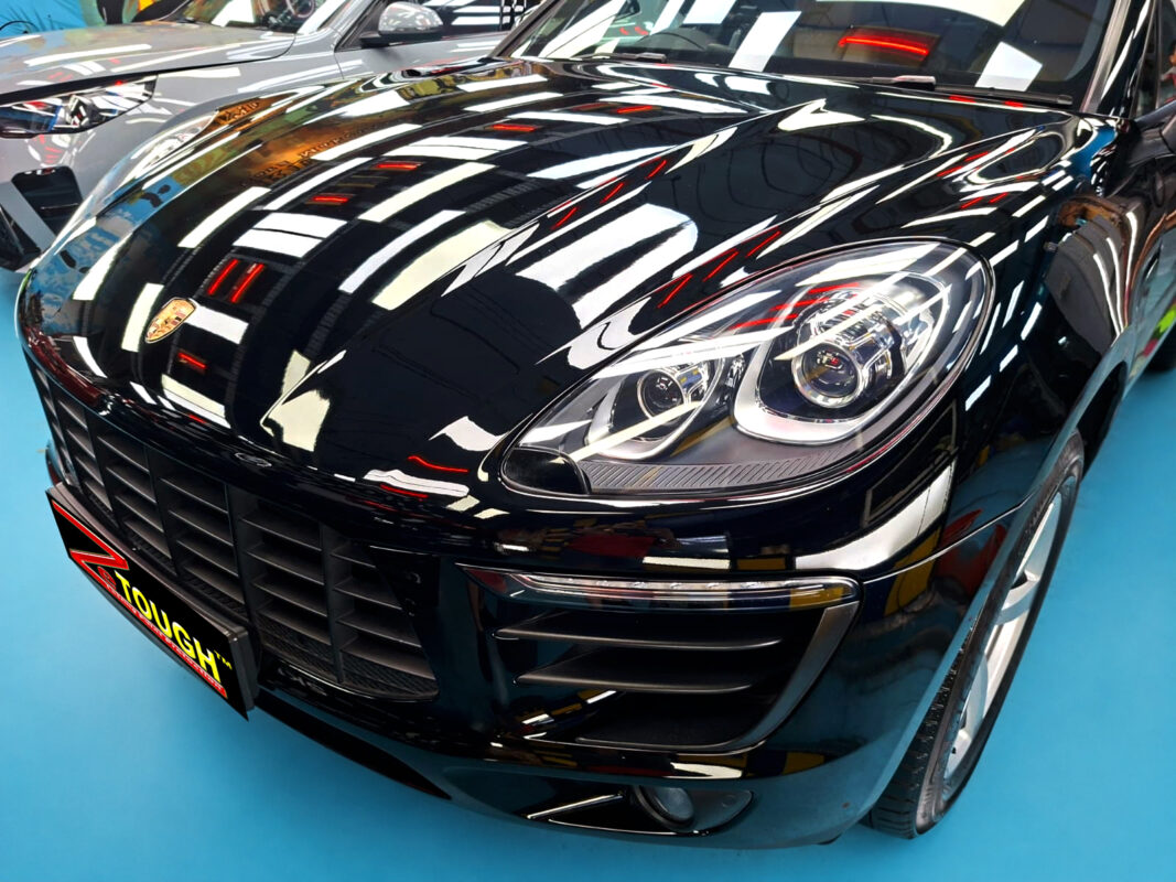 The Porsche Macan's coated paintwork under workshop lighting.