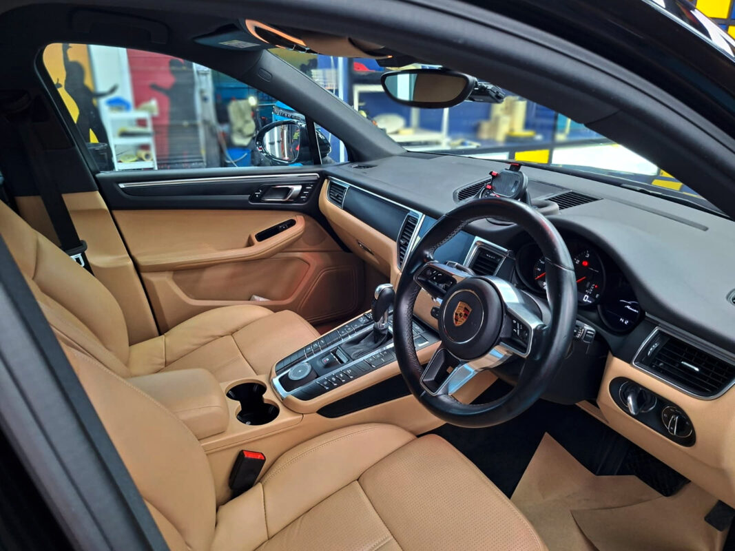 Reflections across the coated panels of the Porsche Macan.