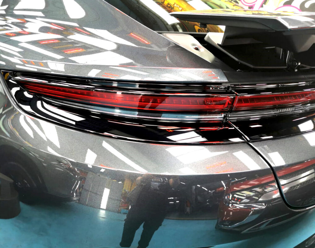 The coated bonnet of the Porsche Panamera under workshop lighting.