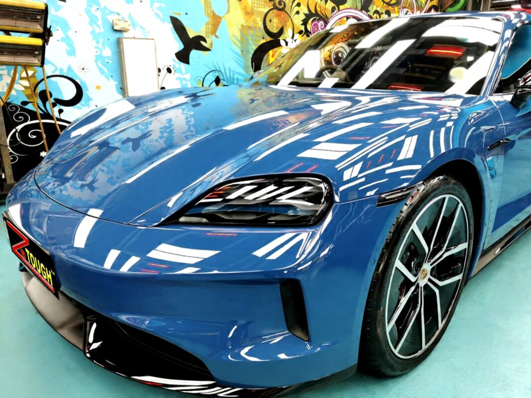 The Porsche Taycan's coated paintwork under workshop lighting.